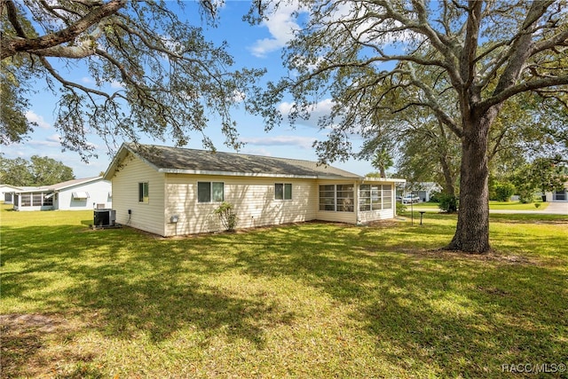 back of house with a yard, central AC unit, and a sunroom