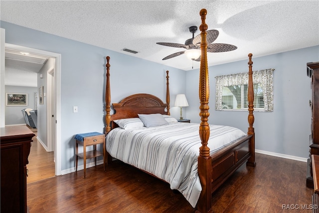 bedroom featuring ceiling fan, dark hardwood / wood-style floors, and a textured ceiling