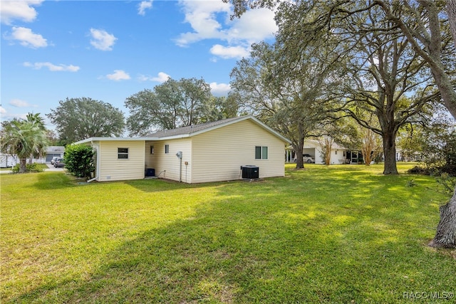 rear view of property featuring a yard and cooling unit