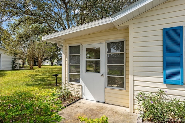 doorway to property with a lawn