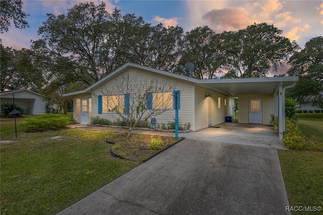 ranch-style home with a lawn and a carport