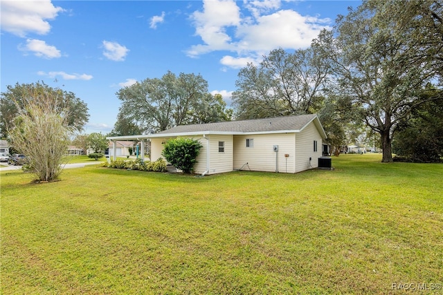 rear view of property featuring a lawn and cooling unit