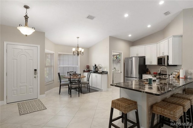 140 W Frisco Ln, Citrus Springs, FL 34434 - kitchen with appliances with stainless steel finishes, a peninsula, white cabinetry, a chandelier, and a breakfast bar