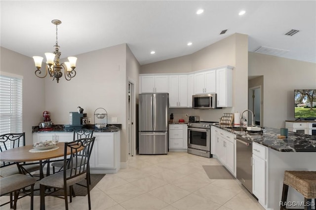 140 W Frisco Ln, Citrus Springs, FL 34434 - kitchen featuring appliances with stainless steel finishes, a peninsula, vaulted ceiling, white cabinets, and a chandelier