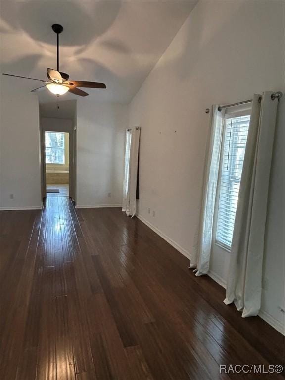 spare room with vaulted ceiling, dark hardwood / wood-style floors, and ceiling fan