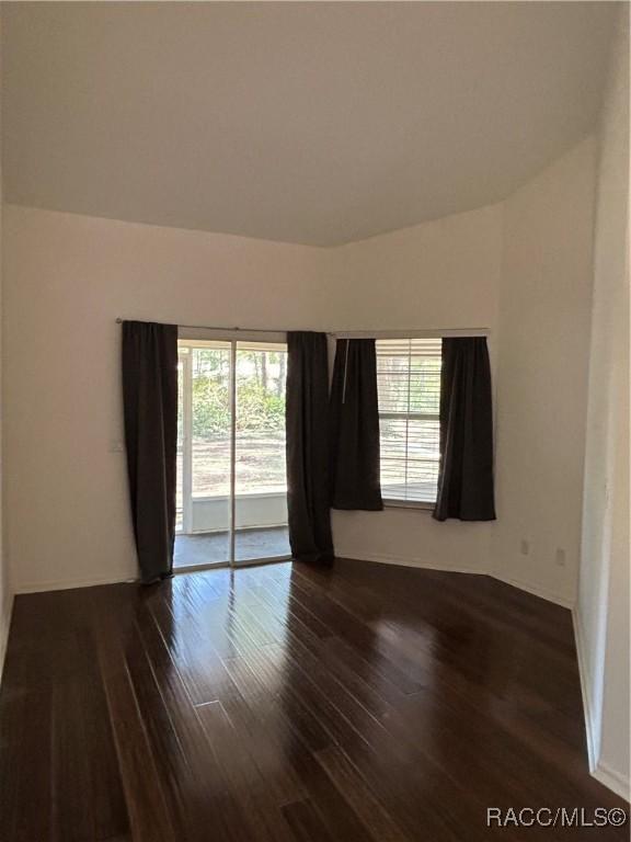 unfurnished room with plenty of natural light and dark hardwood / wood-style floors