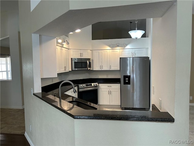 kitchen featuring sink, white cabinetry, kitchen peninsula, pendant lighting, and stainless steel appliances