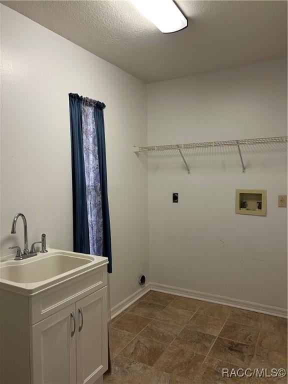 laundry area featuring sink, cabinets, a textured ceiling, washer hookup, and hookup for an electric dryer