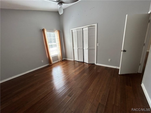 unfurnished bedroom featuring dark wood-type flooring, a closet, and ceiling fan