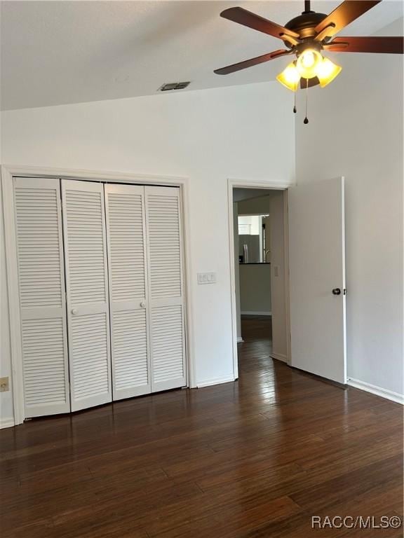 unfurnished bedroom with a closet, dark hardwood / wood-style floors, and ceiling fan