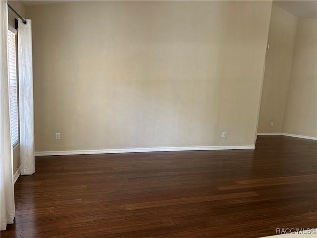 unfurnished room with dark hardwood / wood-style flooring