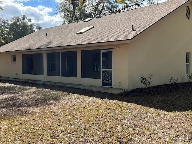 rear view of house featuring a sunroom