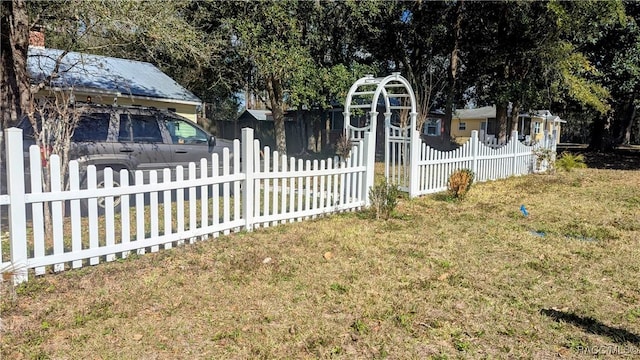 view of gate with a lawn