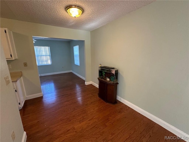 unfurnished room with dark hardwood / wood-style floors and a textured ceiling