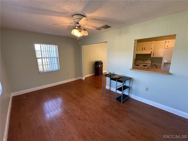 unfurnished room with dark wood-type flooring, a textured ceiling, and ceiling fan