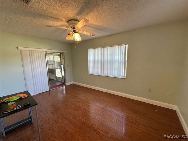 interior space featuring dark hardwood / wood-style floors, access to outside, a textured ceiling, and ceiling fan