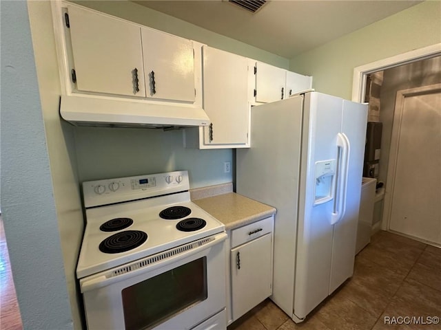 kitchen featuring white cabinetry, white appliances, and dark tile patterned floors