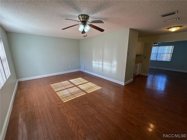 spare room with dark wood-type flooring, ceiling fan, and a textured ceiling