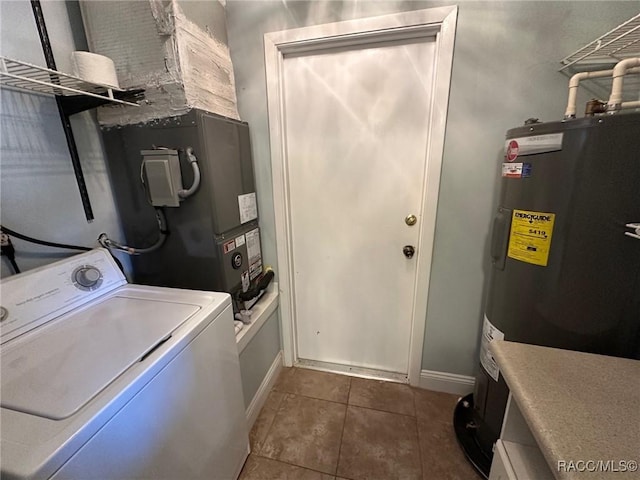 washroom with washer / dryer, electric water heater, and dark tile patterned flooring