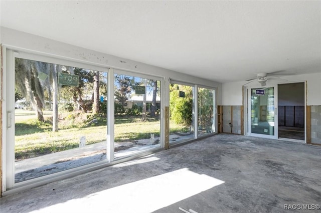 unfurnished sunroom featuring ceiling fan