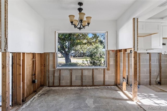 interior space with a chandelier, visible vents, and concrete flooring