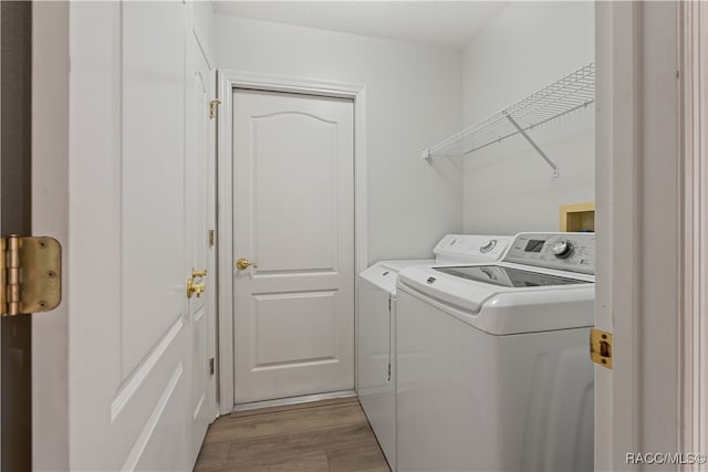 laundry area featuring light wood-type flooring and washer and clothes dryer