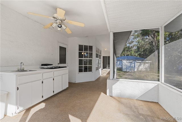 sunroom with ceiling fan, sink, and lofted ceiling