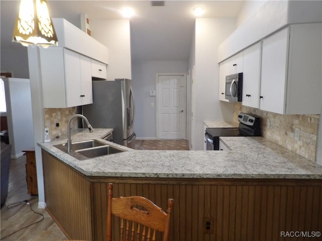 kitchen featuring tasteful backsplash, sink, white cabinets, and appliances with stainless steel finishes