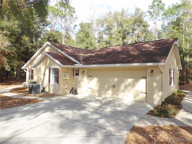 view of front of property featuring a garage and cooling unit