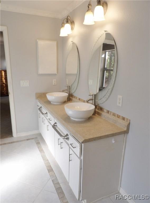 bathroom featuring crown molding, vanity, and tile patterned flooring