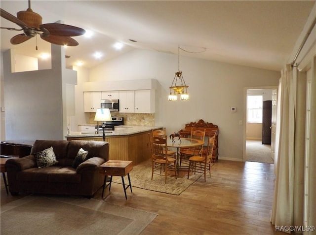 interior space with tasteful backsplash, light hardwood / wood-style flooring, kitchen peninsula, stainless steel appliances, and white cabinets