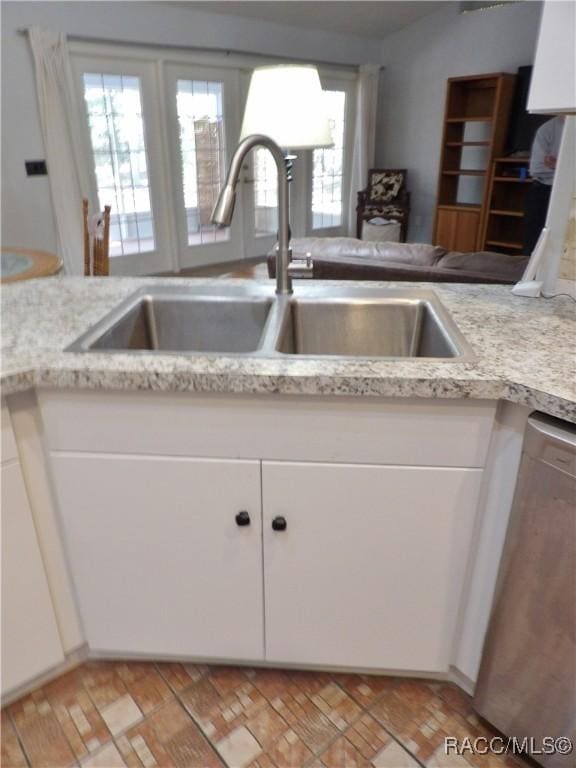 kitchen with white cabinetry, sink, and dishwasher