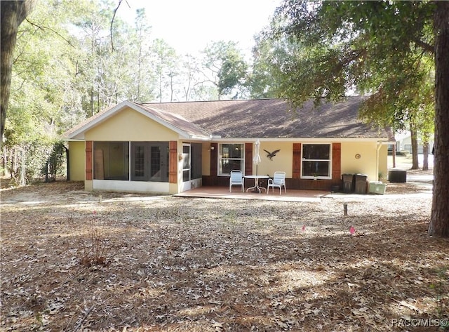 rear view of property featuring a patio, a sunroom, and cooling unit