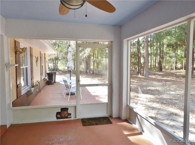 unfurnished sunroom featuring ceiling fan