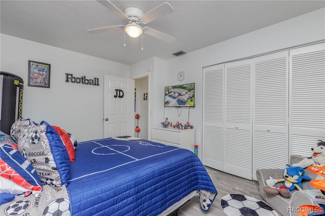 bedroom with light wood-type flooring, a closet, and ceiling fan