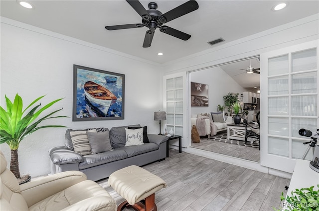 living room featuring ceiling fan, french doors, light hardwood / wood-style floors, vaulted ceiling, and ornamental molding