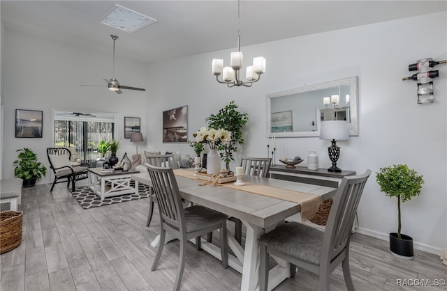 dining room with light hardwood / wood-style flooring and ceiling fan with notable chandelier