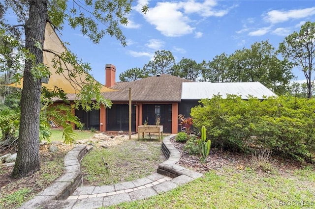 4105 W Tomahawk Dr, Beverly Hills, FL 34465 - rear view of property with a sunroom and a chimney