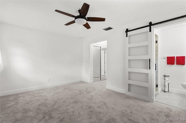 3874 N Timucua Pt, Crystal River, FL 34428 - unfurnished bedroom featuring carpet, a barn door, and a ceiling fan