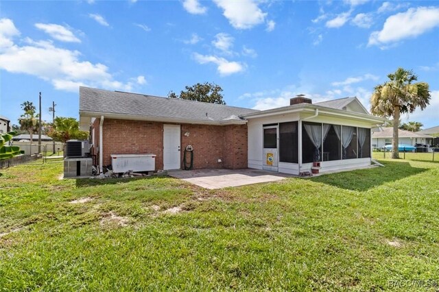 3874 N Timucua Pt, Crystal River, FL 34428 - back of house featuring a sunroom, a patio area, brick siding, and a chimney