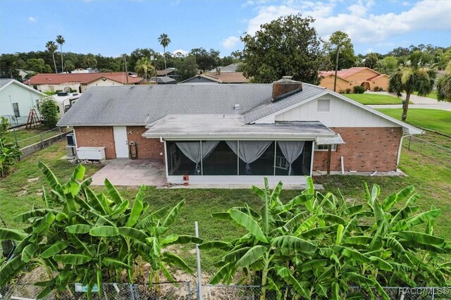 3874 N Timucua Pt, Crystal River, FL 34428 - rear view of house featuring a sunroom, brick siding, a patio area, and a chimney