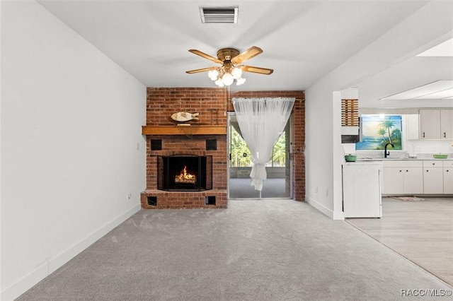3874 N Timucua Pt, Crystal River, FL 34428 - unfurnished living room featuring a ceiling fan, a brick fireplace, and light carpet