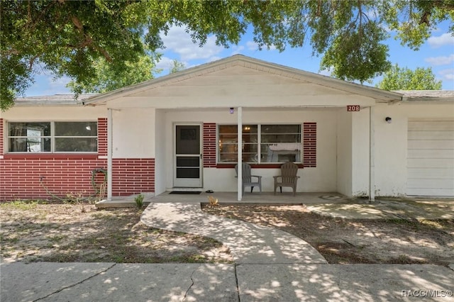 208 S Adams St, Beverly Hills, FL 34465 - view of front facade with a garage, brick siding, and stucco siding