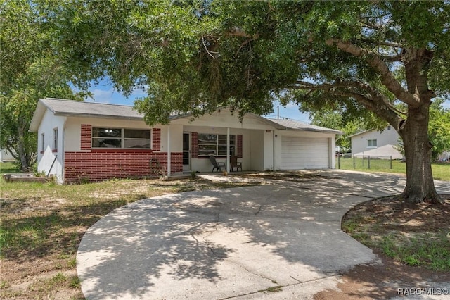 208 S Adams St, Beverly Hills, FL 34465 - view of front of home featuring brick siding, driveway, and an attached garage