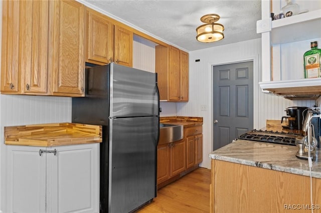 208 S Adams St, Beverly Hills, FL 34465 - kitchen featuring freestanding refrigerator, light wood-style floors, and a sink