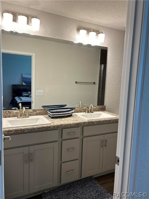 bathroom featuring vanity, wood-type flooring, and a textured ceiling