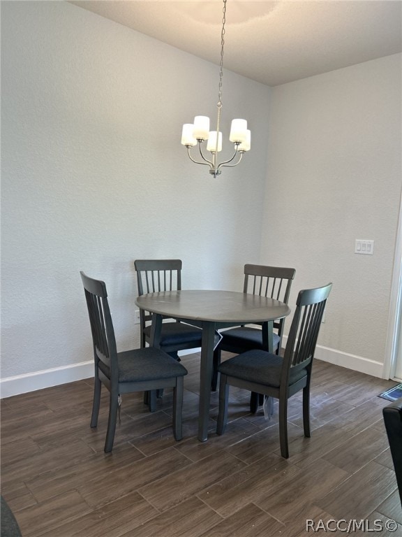 dining space featuring dark hardwood / wood-style flooring and an inviting chandelier