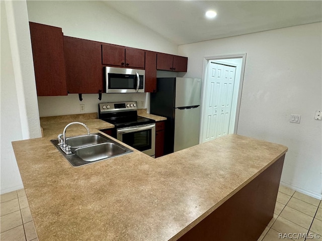 kitchen with sink, stainless steel appliances, kitchen peninsula, vaulted ceiling, and light tile patterned floors