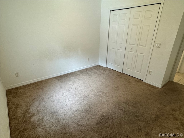 unfurnished bedroom featuring carpet and a closet