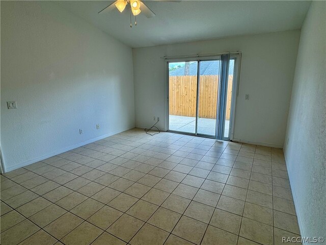 empty room with ceiling fan and light tile patterned flooring